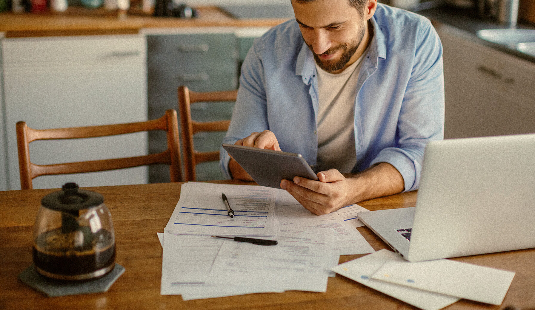 Mann mit Tablet in der Hand stellt auf Online Rechnung um