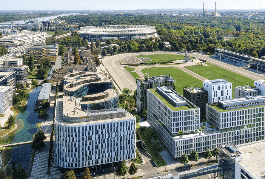 Luftaufnahme moderner Bürogebäude, umgeben von Grün.