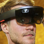 Wien Energie Mitarbeiter passt Augmented-Reality-Headset mit beiden Händen an, tätowierter Arm sichtbar.