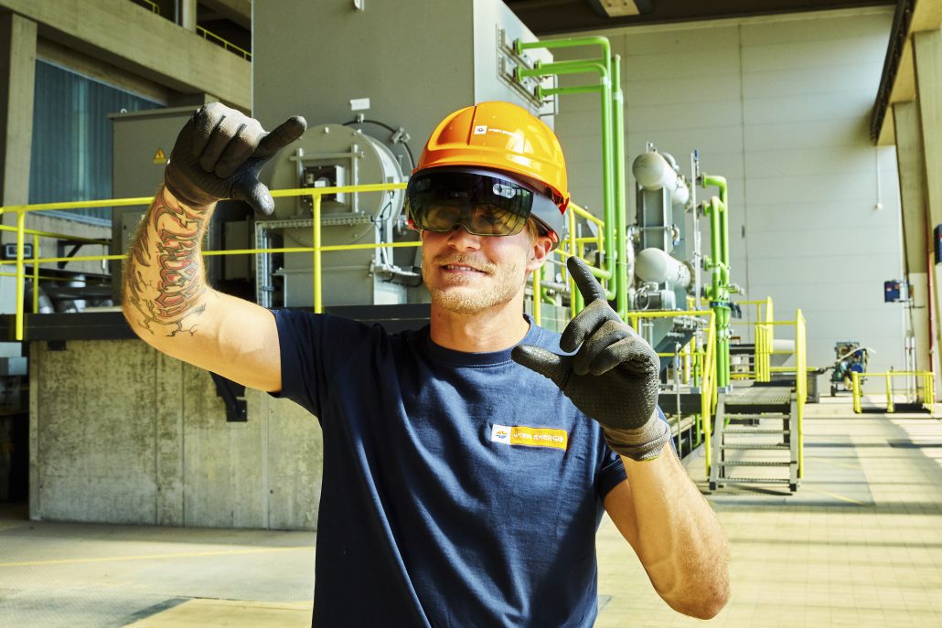 Arbeiter im Biomassekraftwerk Simmering in Schutzausrüstung trägt eine Datenbrille.