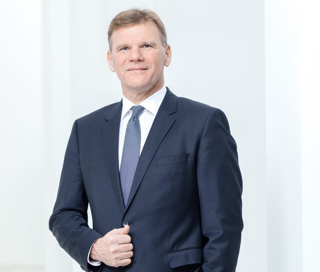 Michael Strebl, Geschäftsführer von Wien Energie, steht in dunklem Anzug und Krawatte vor hellem Hintergrund,