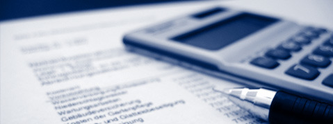 Taschenrechner und Kugelschreiben liegen auf der Rechnung