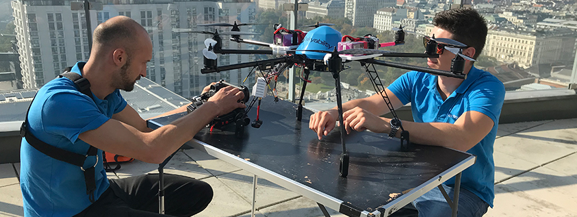 Das Bild zeigt zwei Männer mit einer Drohne die zur Inspektion für Photovoltaikanlagen eingesetzt wird