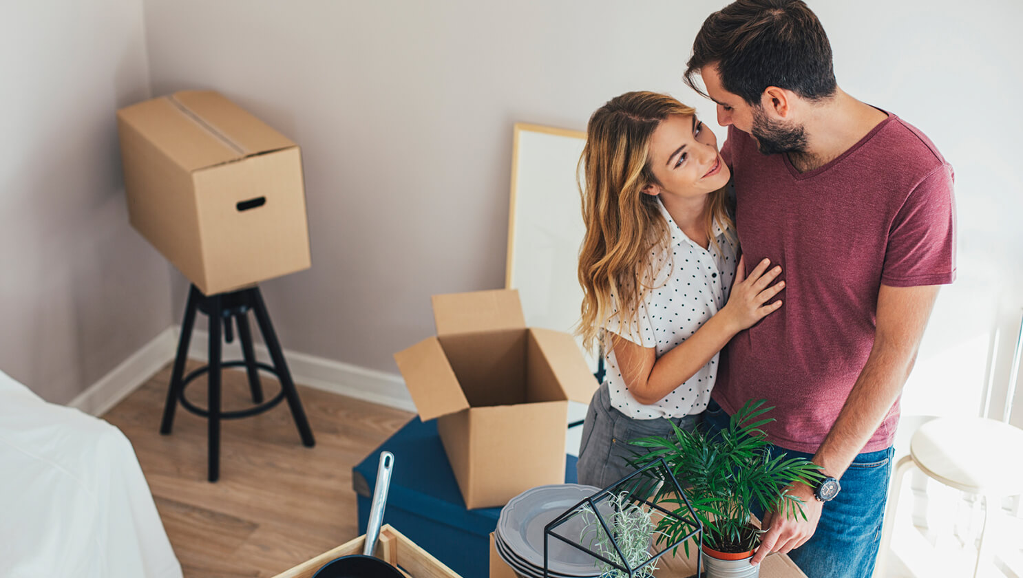 Paar_umarmt _sich_vor_Umzugskartons