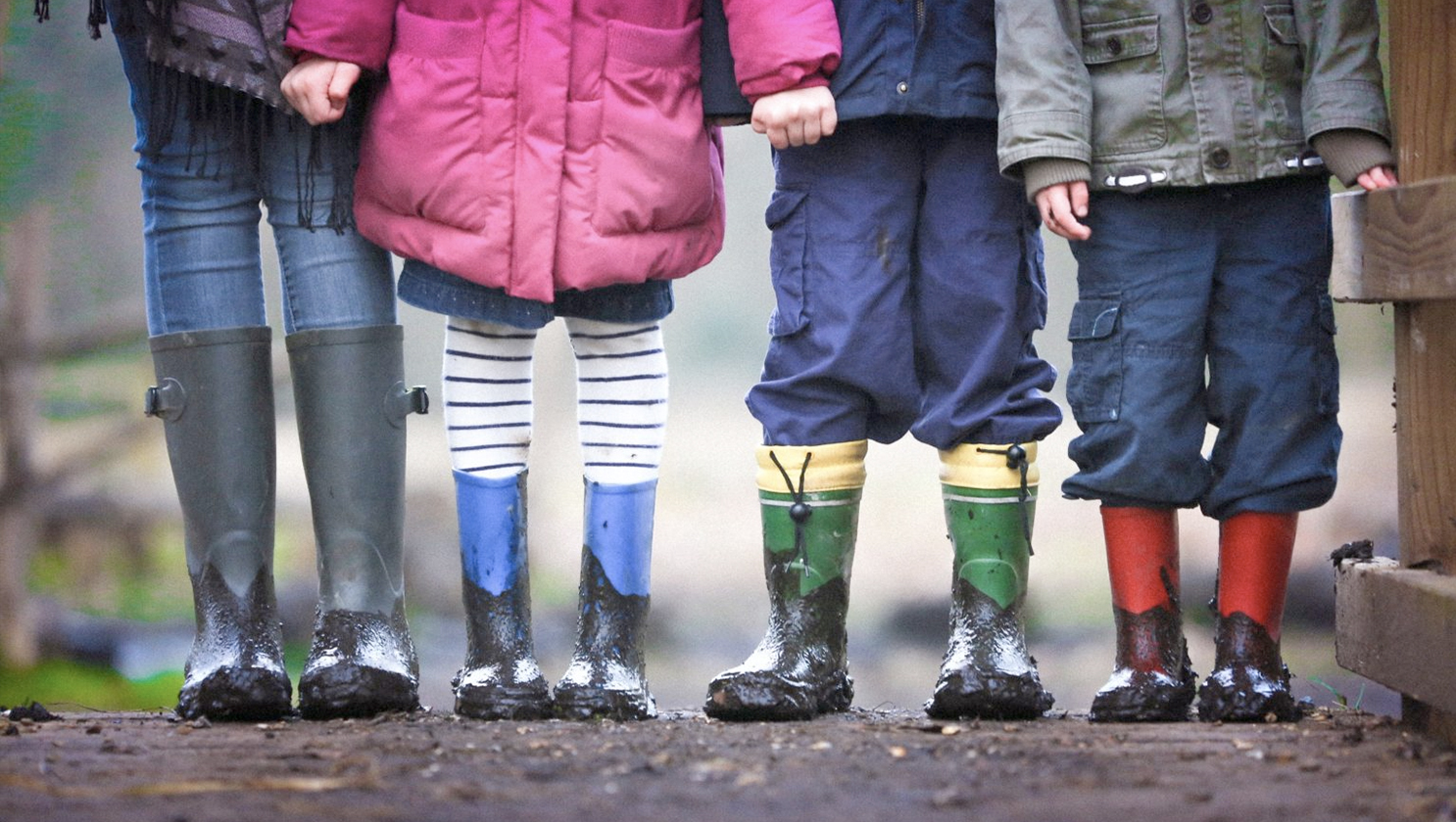kinder_mit_gummistiefeln_in_einer_reihe