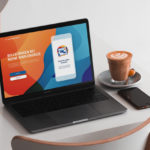 Laptop mit einer farbenfrohen Website, die die online Services von Wien Energie zeigt. Daneben ein Smartphone und ein Kaffee auf einem Tisch.