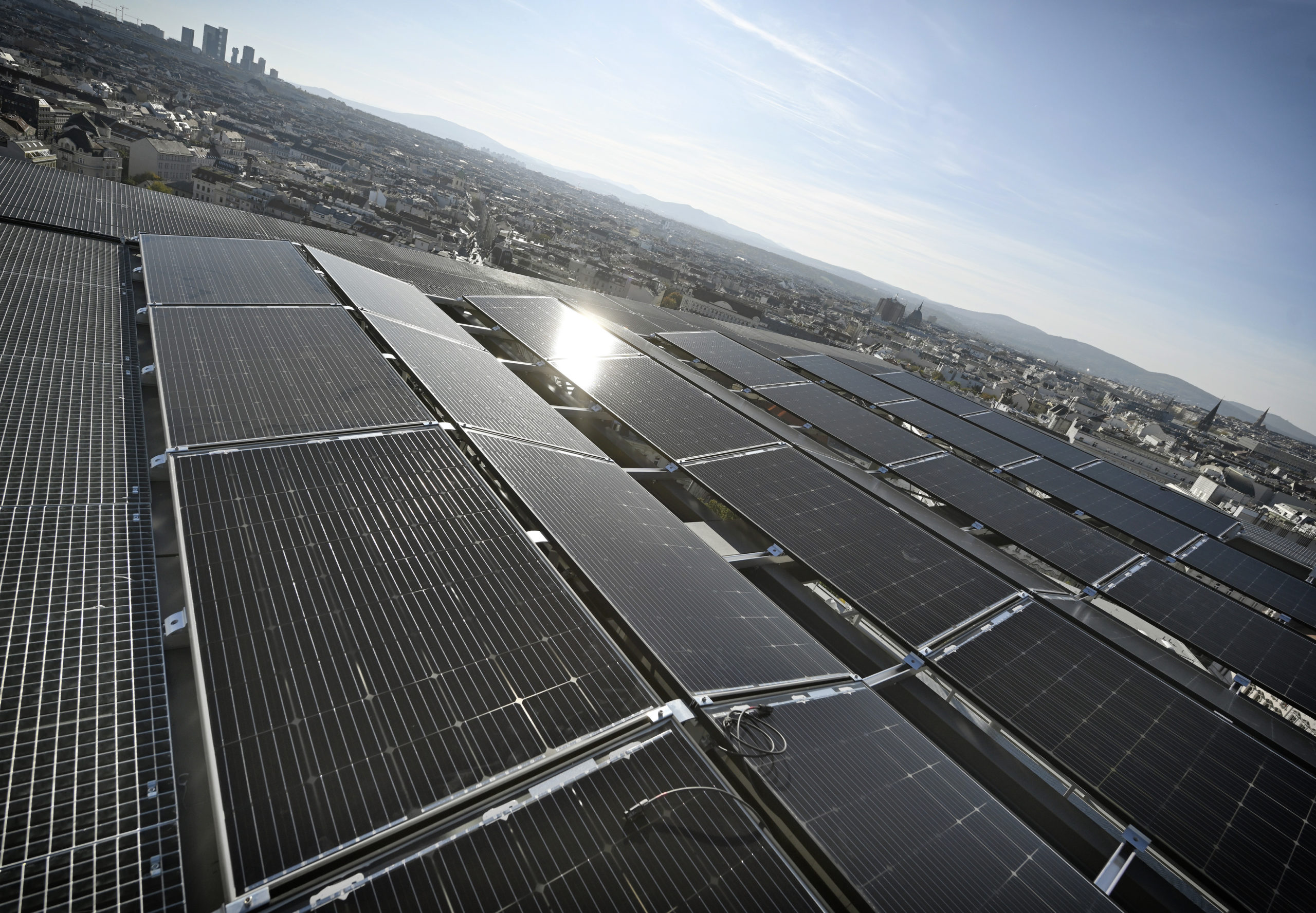 Solarmodule auf dem Dach des Haus des Meeres. Im Hintergrund ist die Wiener Stadtlandschaft bei klarem Himmel zu sehen.