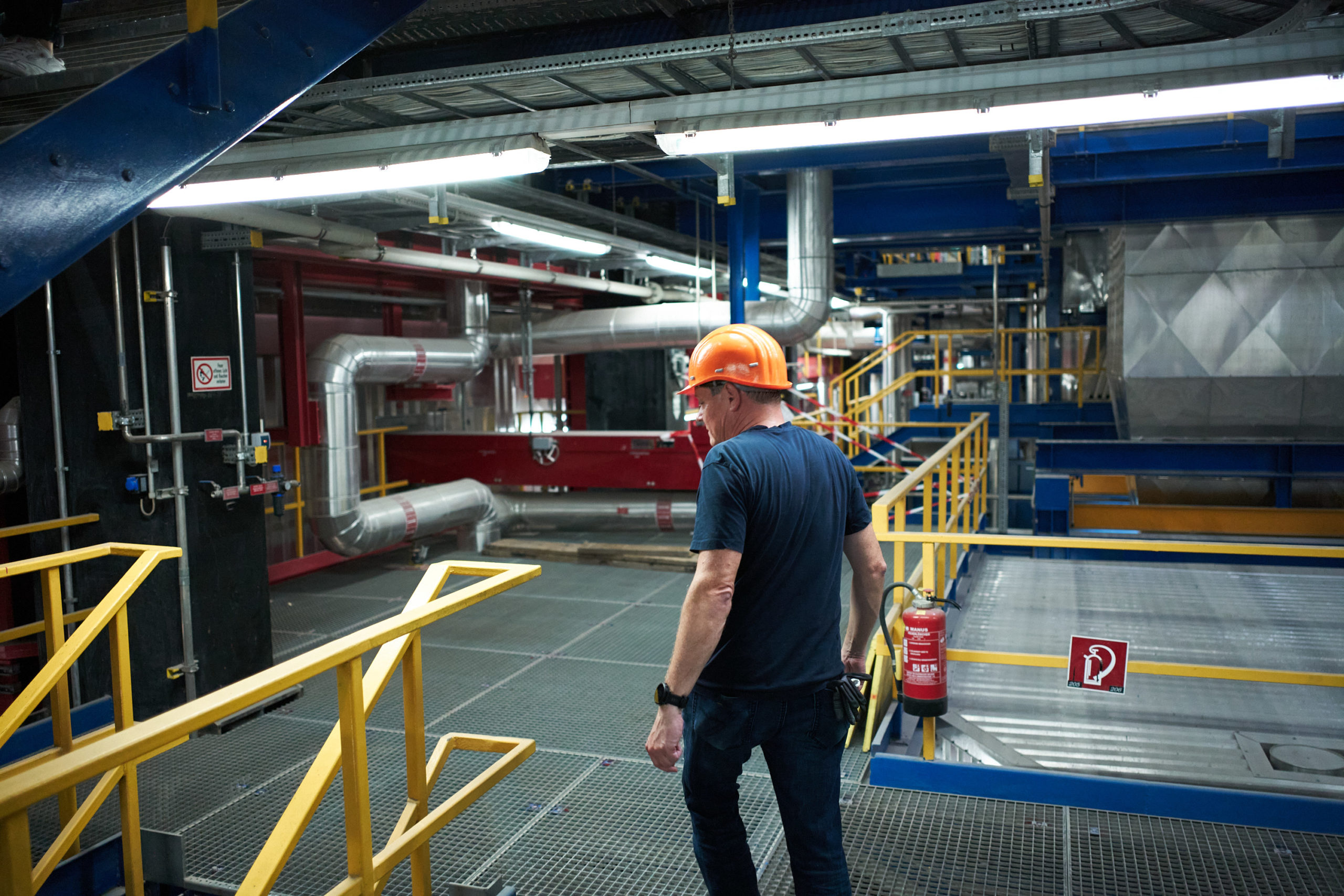 Arbeiter mit orangefarbenem Helm geht durch eine Abfallverwertungsanlage Spittelau.