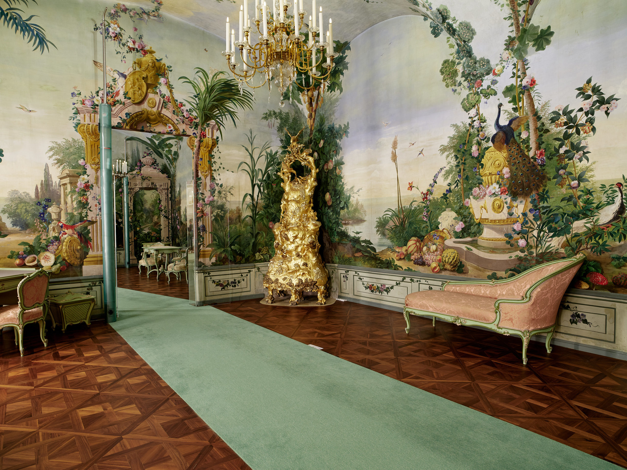 Zimmer in der Privatresidenz von Maria Theresia. Grüner Teppich im Raum kunstvoll gestaltete Wände mit Pflanzenmalereien.