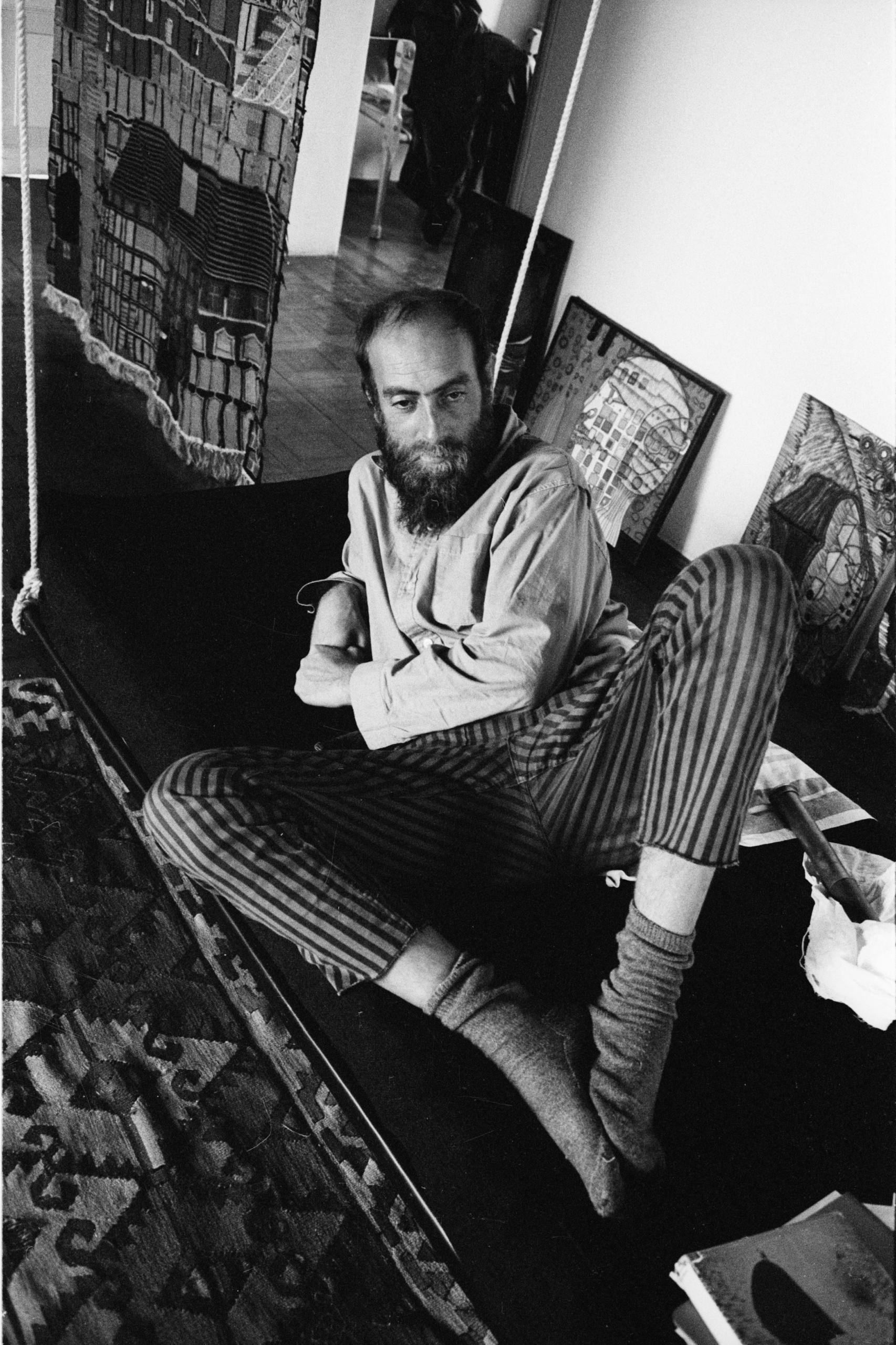 Junger Friedrich Hundertwasser liegt auf der Couch. Schwarz-Weiß Aufnahme.