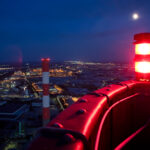 Wiener Stadtbild bei Nacht mit einem roten Warnlicht im Vordergrund und im Vollmond beleuchteten Gebäuden.