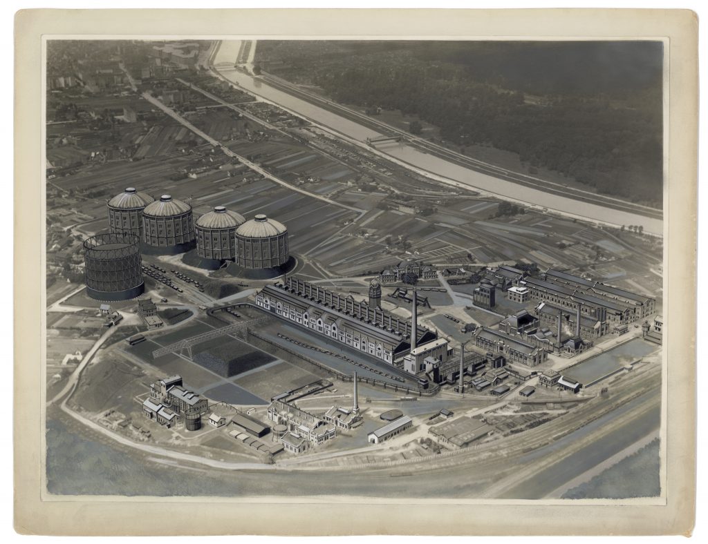 Schwarzaufnahme vom Gasometer aus der Luft, Aufnahme aus dem Jahr 1910. Der Gasometer ist von Äckern ungeben.