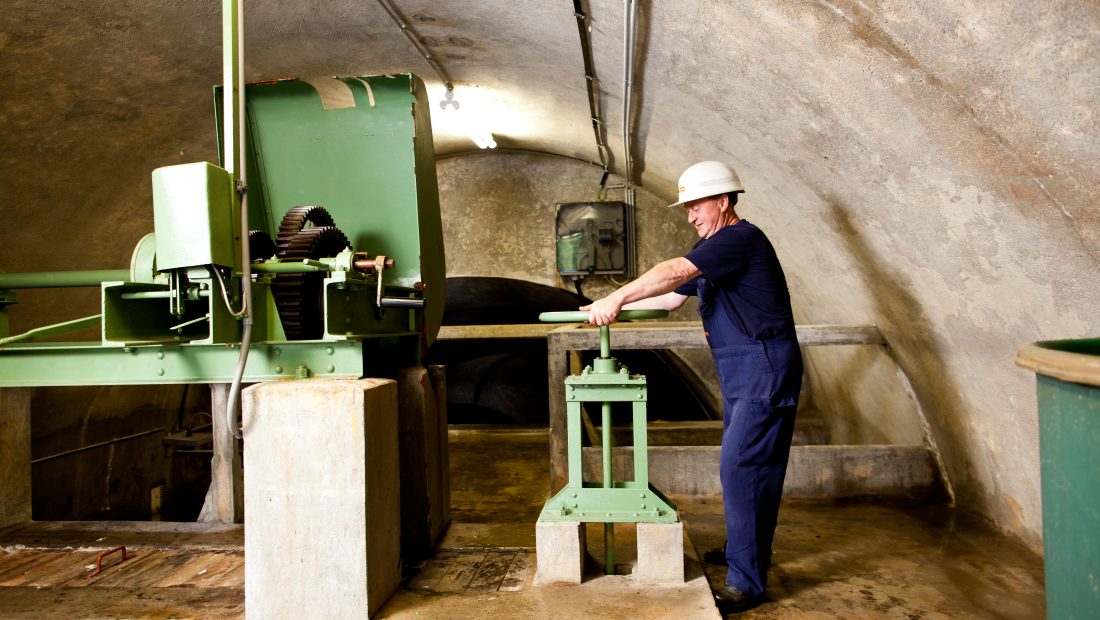 Mann betätigt Drehkurbel im Kleinwasserkraftwerk Gaming.