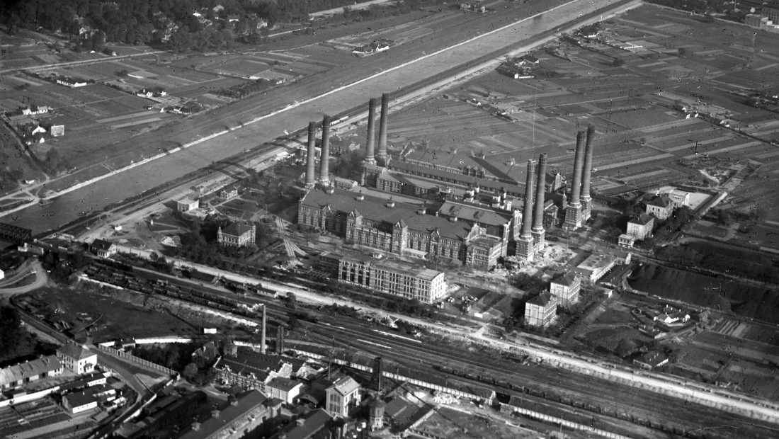 Luftaufnahme vom Kraftwerk Simmering mit mehreren Schornsteinen und den umliegenden Feldern, Aufnahme aus dem Jahr 1928.