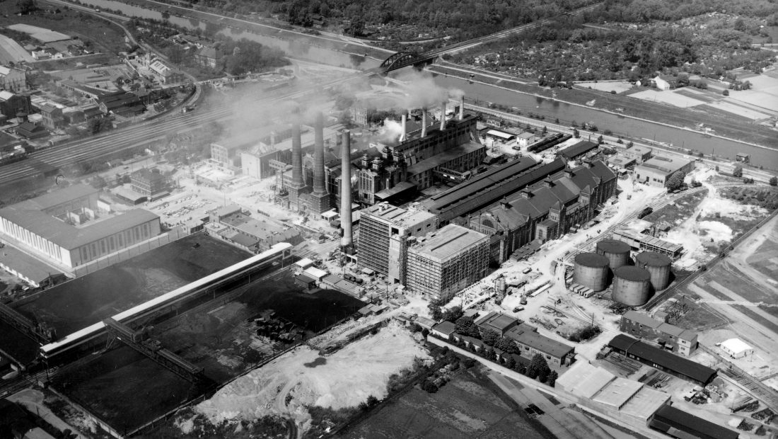Historische Luftaufnahme vom Kraftwerk Simmering as dem Jahr 1961. Das Kraftwerk ist umgeben von Bäumen und Äckern.