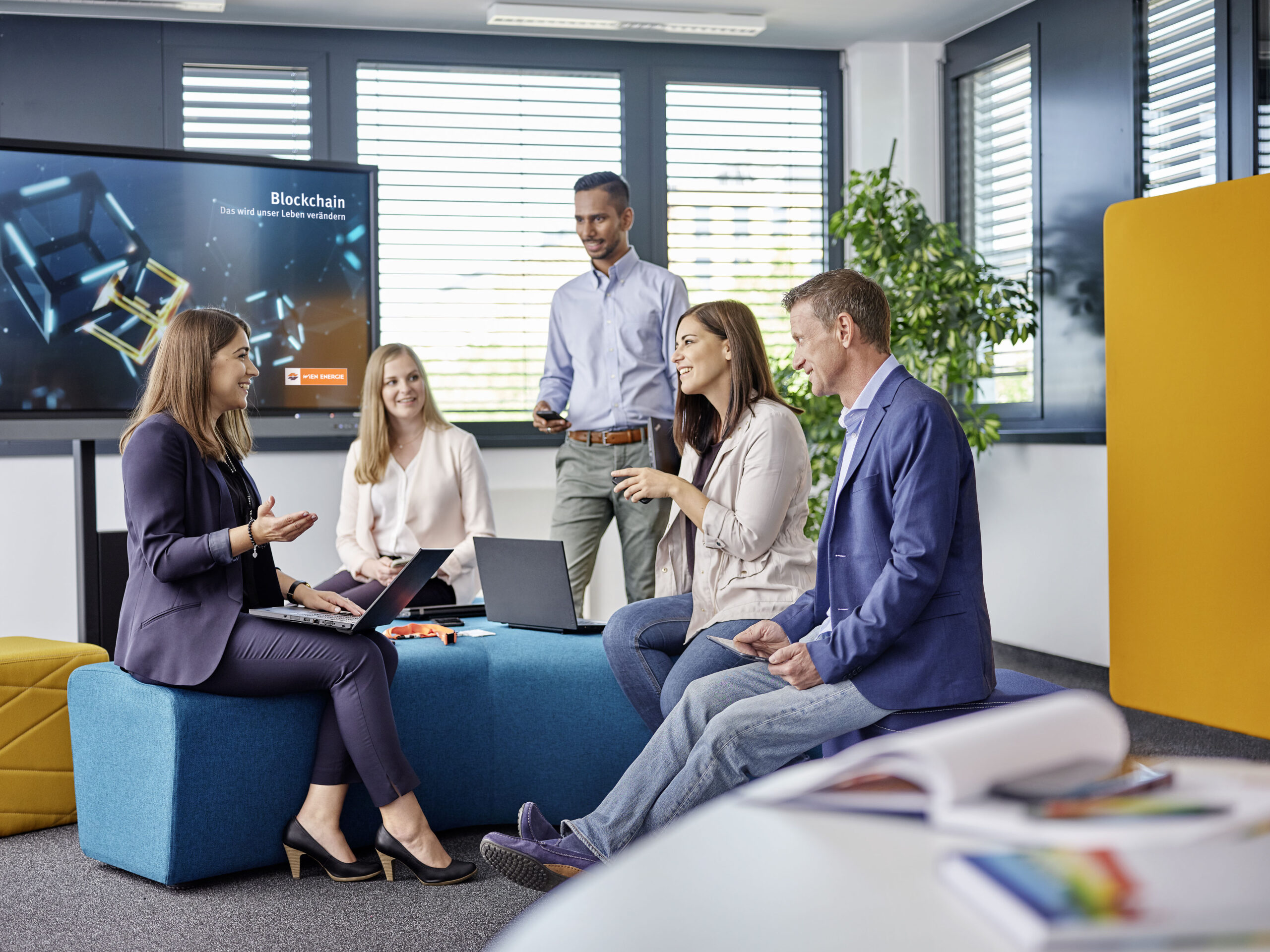 Büro Mitarbeiter*innen diskutieren in einem offenen Meetingraum