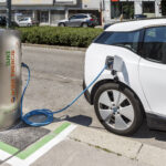Ein Elektroauto wird an einer Station von „Wien Energie“ in einer Stadtstraße aufgeladen.