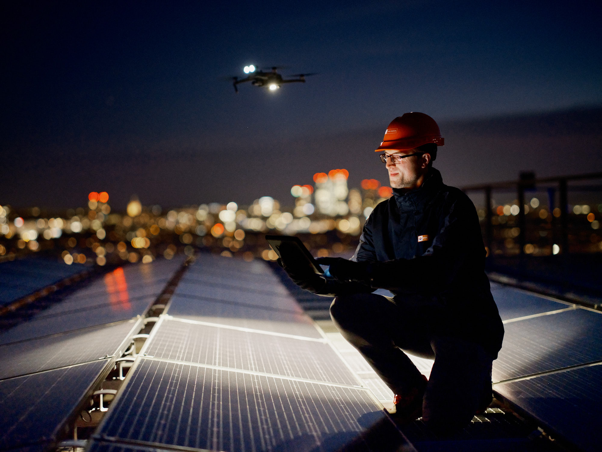 Drohneninspektion einer Photovoltaikanlage bei Nacht.