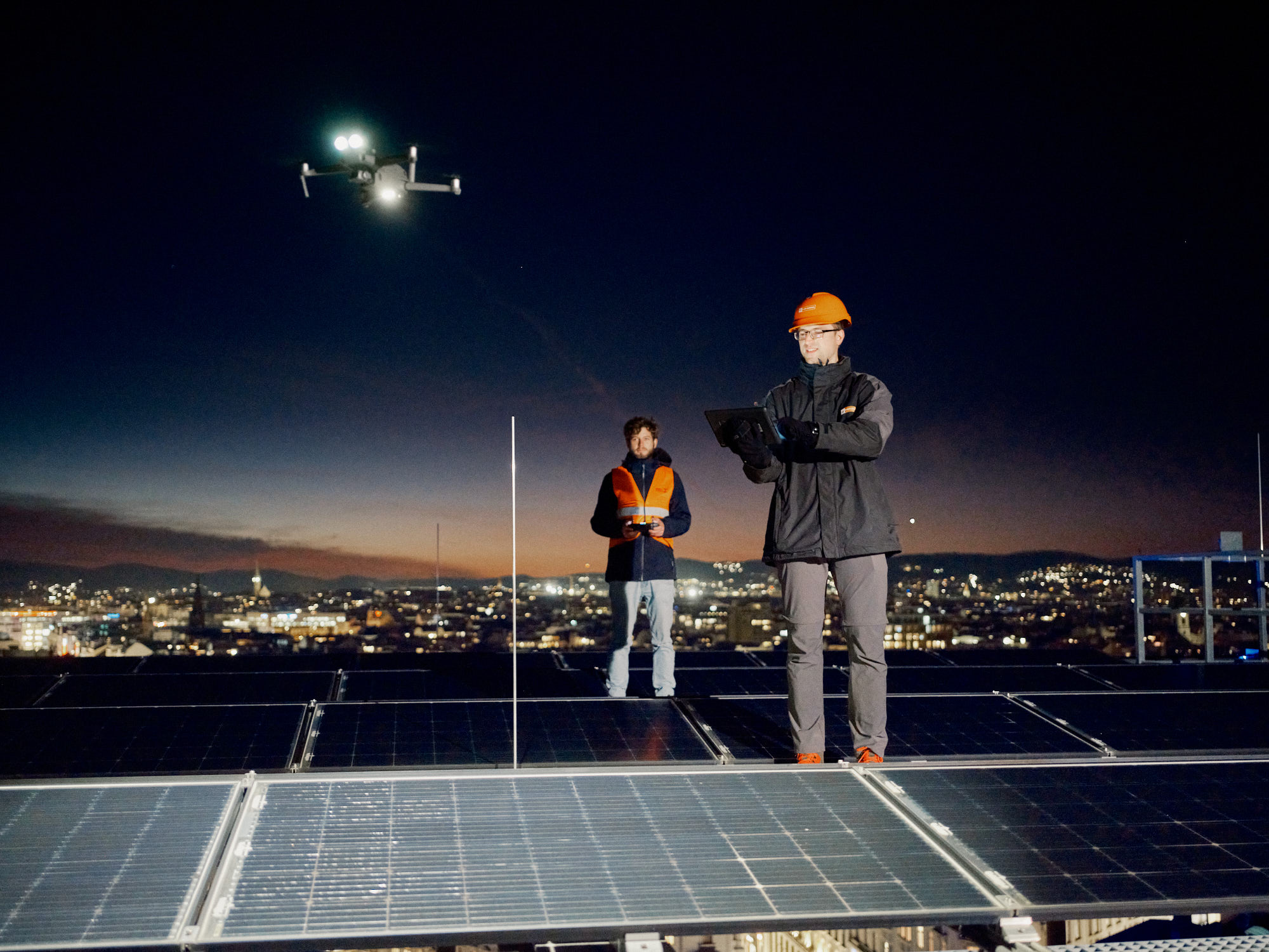 Drohneninspektion einer Photovoltaikanlage bei Nacht.