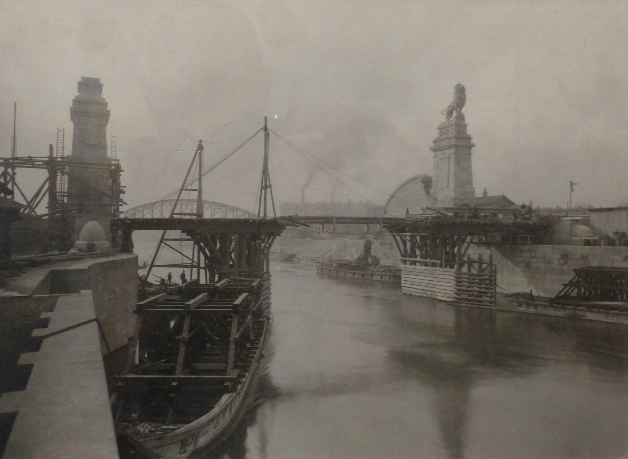 Bau der Nussdorfer Wehr Brücke, mit Gerüsten und Kränen, im Hintergrund eine Löwenstatue.