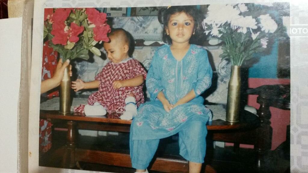 Tahira als Kind rechts in Blau neben inem Baby in Lila.