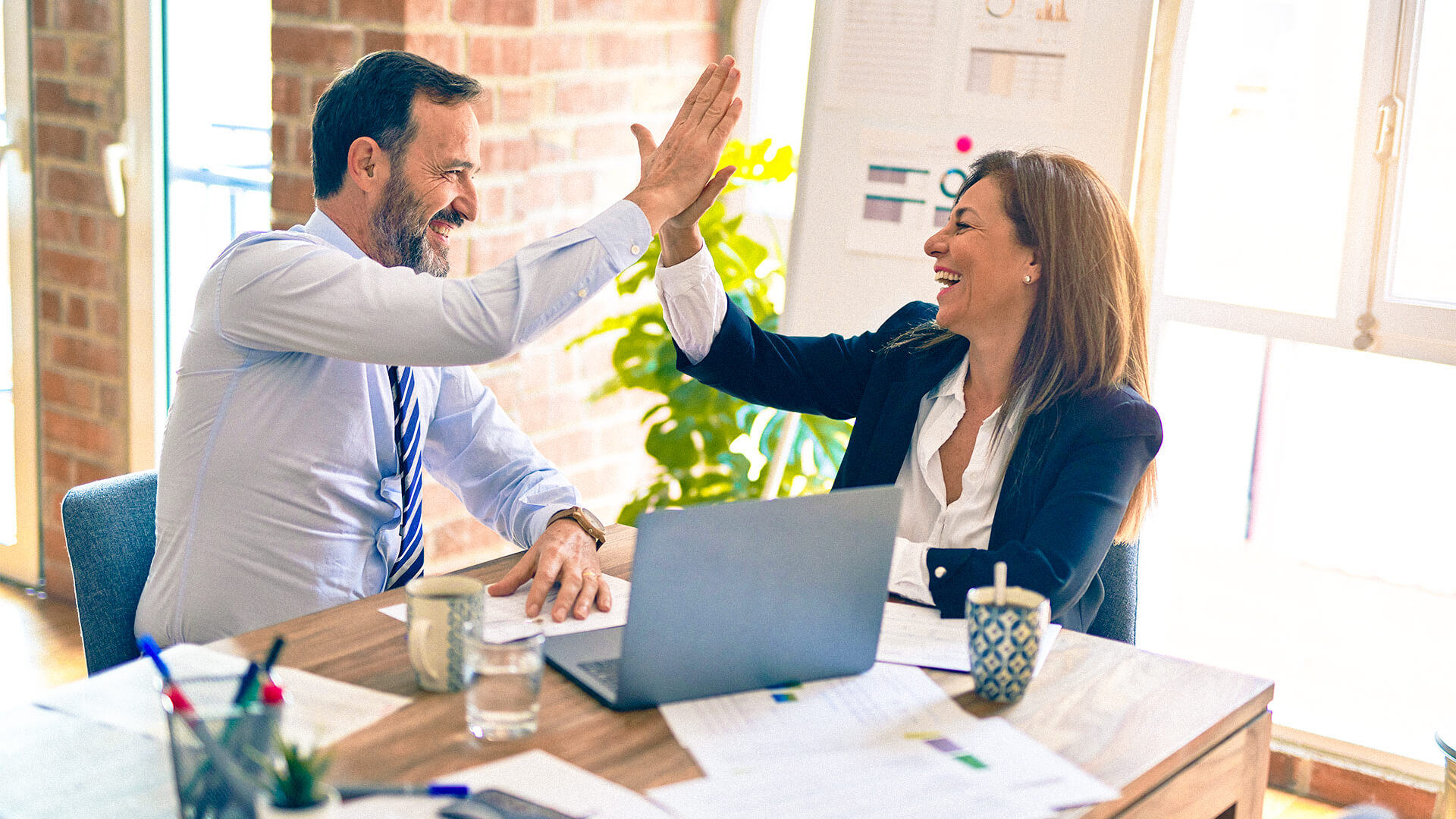 Kollegen klatschen sich für gute Arbeit ab.