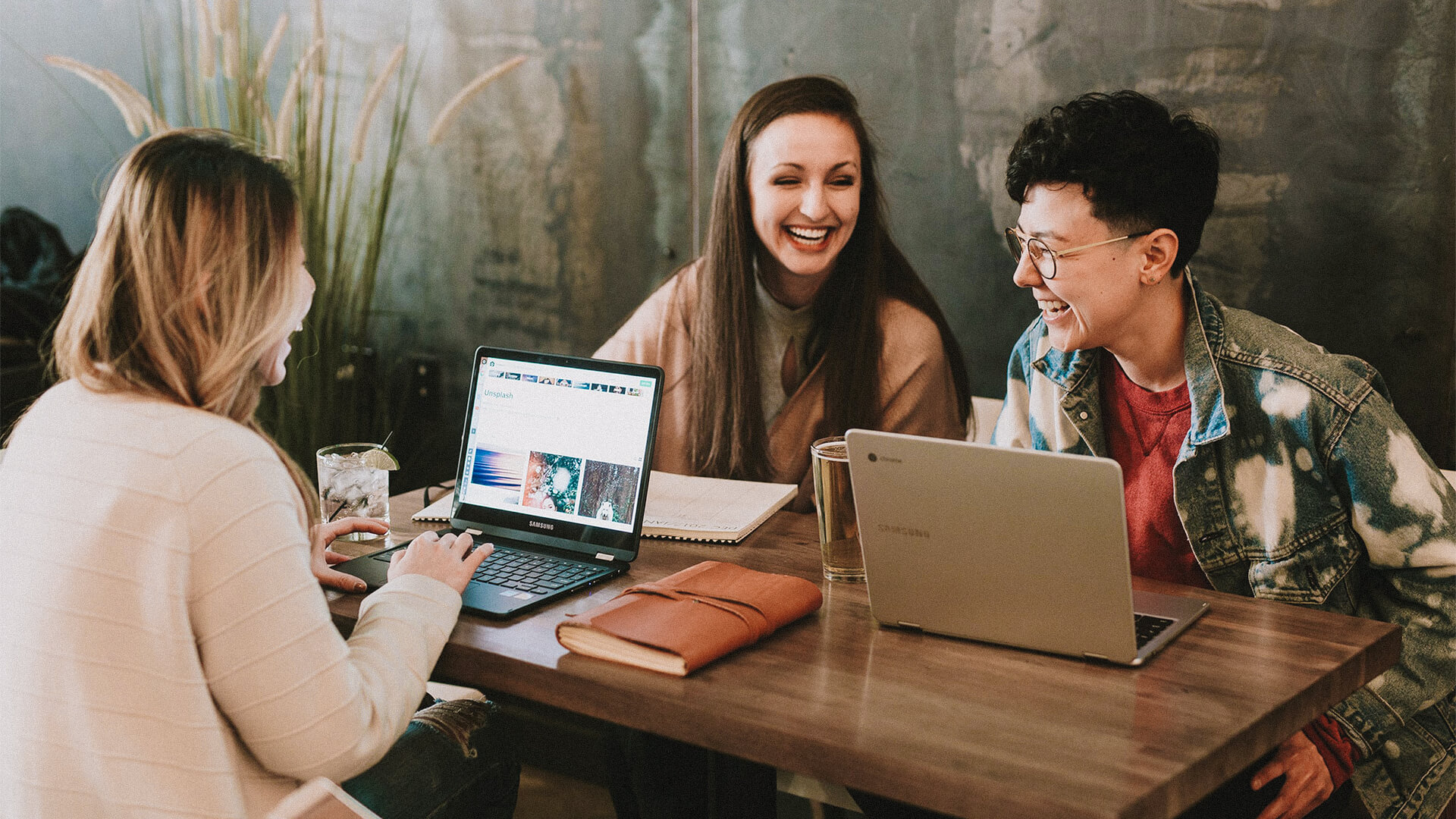 Junge Menschen arbeiten mobil und lächeln dabei.