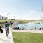 Das Bild Zeigt Fußgänger und Badegäste in der Seestadt Aspern.