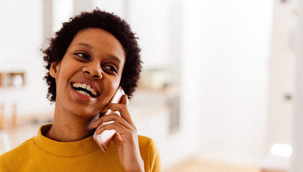 Lächelnde Frau mit Telefon in der Hand