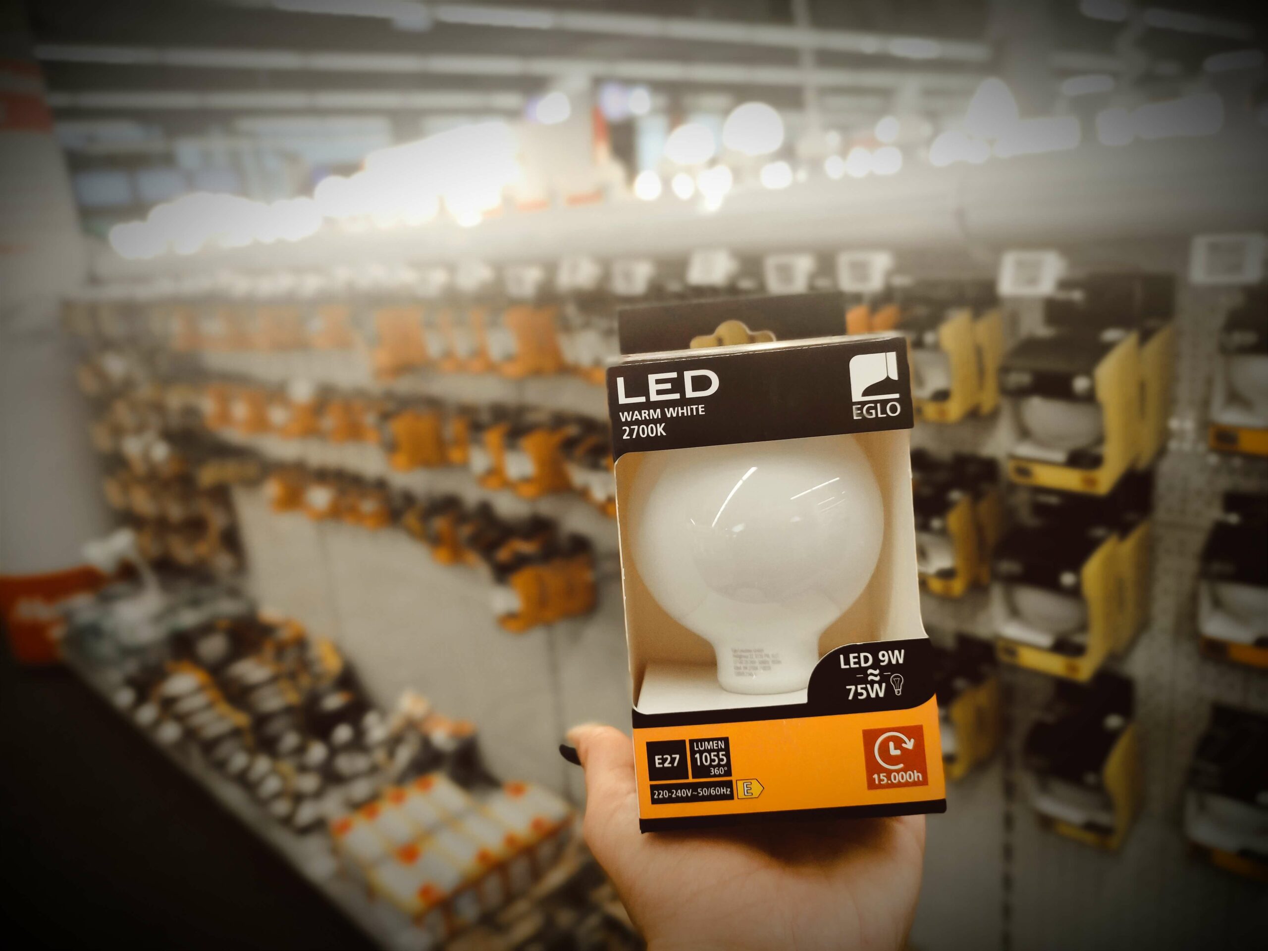 Jemand hält in einem Geschäft eine LED-Lampe in der Hand.