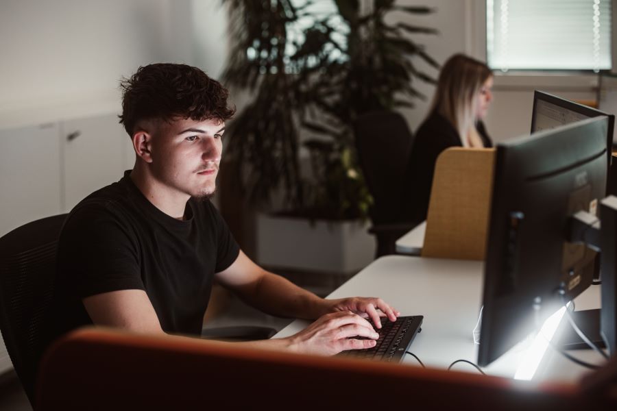 Junger Mann sitzt vor Computer