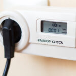 Strommessgerät steckt an einer Steckdose und zeigt den Stromverbrauch an.