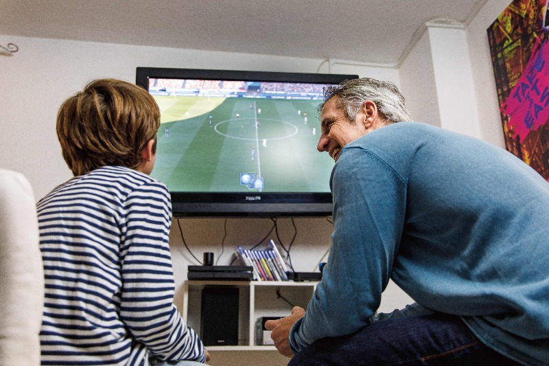 Kind und Vater spielen FIFA