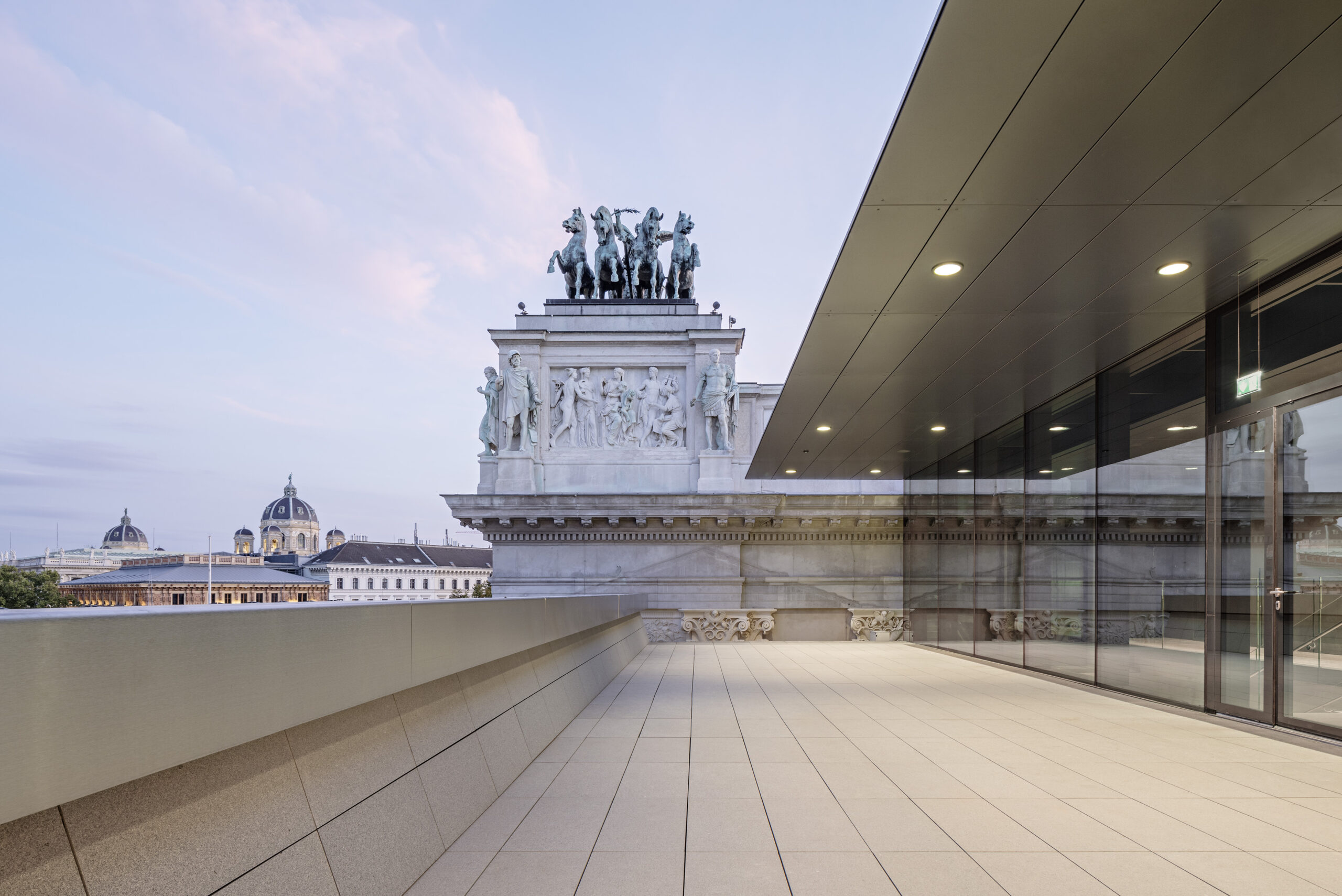 Die Hofburg-Terrasse mit Blick auf eine Quadriga. Im Hintergrund ist eine Statue zu sehen.