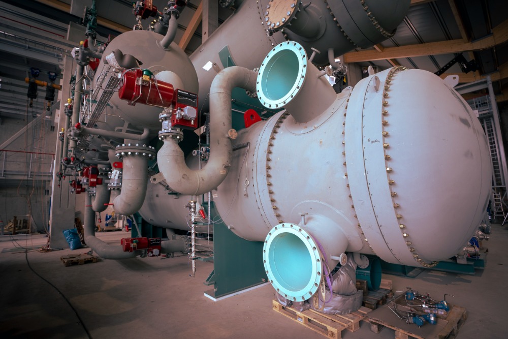 Die ebswien Großwärmepumpe mit großen Rohren und Ventilen in einer Lagerhalle.
