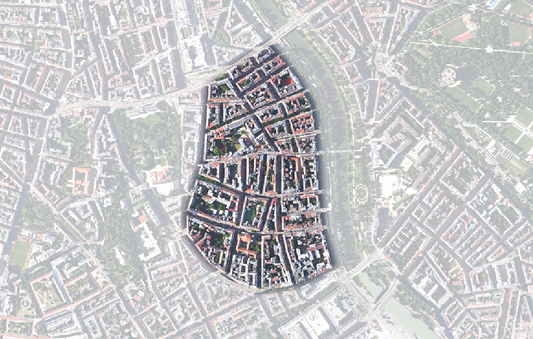 Luftaufnahme eines von einem Fluss umgebenen Stadtgebiets (Rossau) mit dicht gedrängten Gebäuden und sich kreuzenden Straßen.
