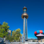 Die Abfallverwertungsanlage Spittelau mit dem butnen Kapperl bei blauem Himmel und Sonnenschein.