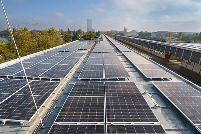 Photovoltaikanlage am Dach der U-Bahn-Station U1 Alte Donau. Im Hintergrund ist das Wiener Stadtbild zu erkennen.