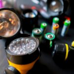 Taschenlampe und Batterien liegen nebeneinander.