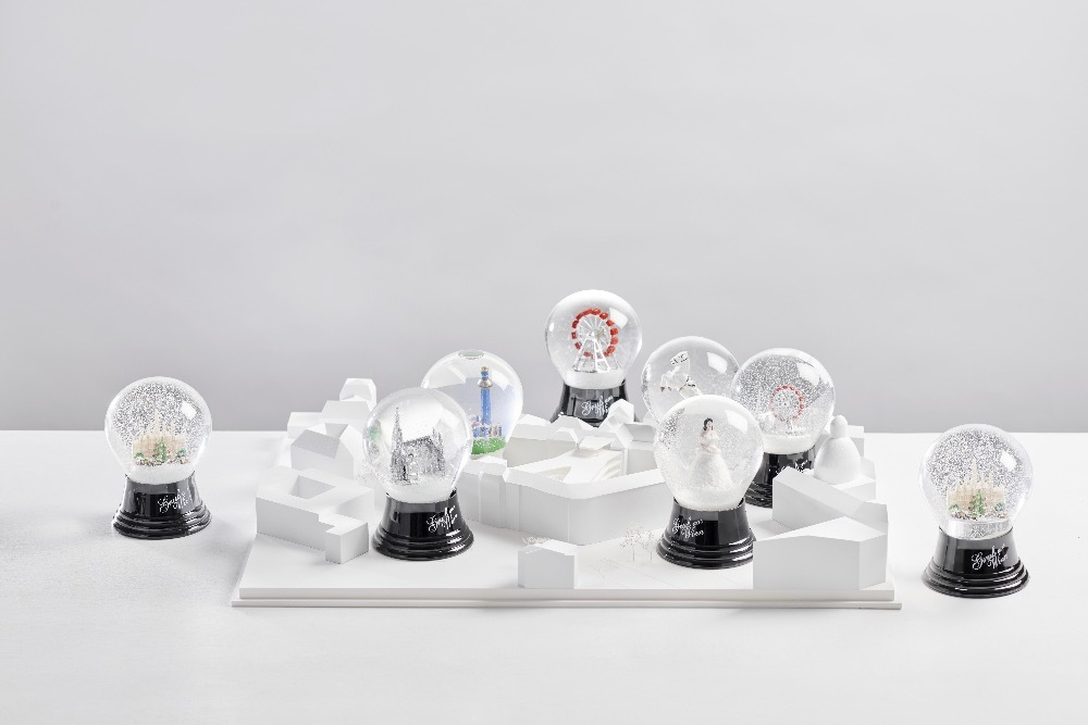 Schneekugeln aus der Wiener Schneekugelmanufaktur angeordnet auf einem Modell des Architekturbüro Franz &amp; Sue