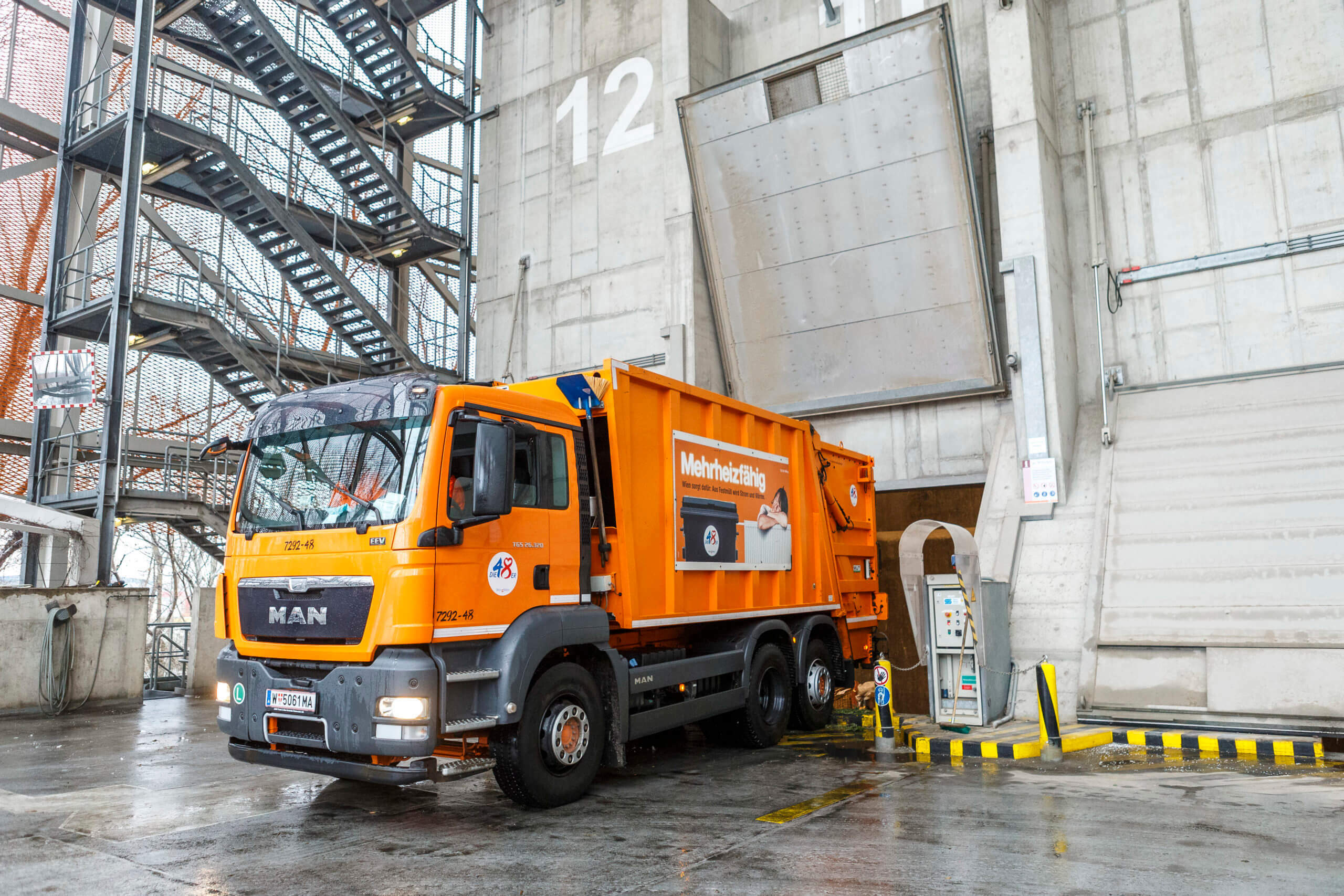 Ein orangefarbener Müllwagen lädt Abfall in der Müllverbrennungsanlage Pfaffenau ab.