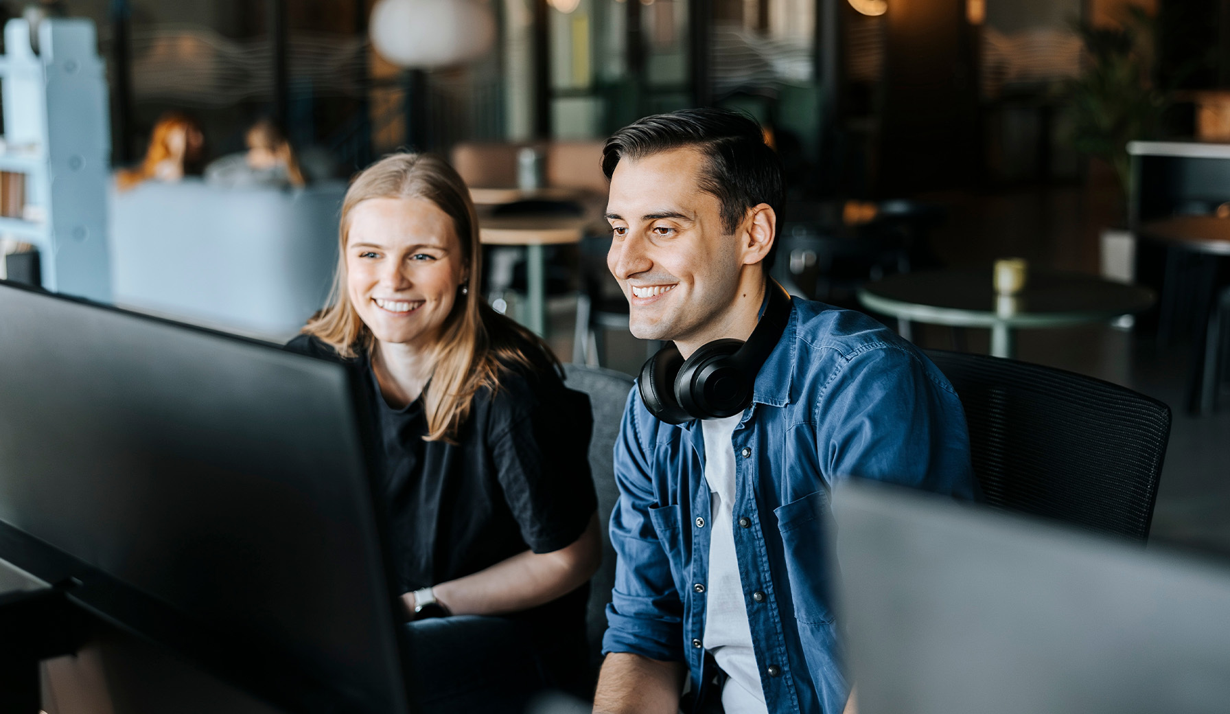 Eine Mann und eine Frau sitzen vor einem PC