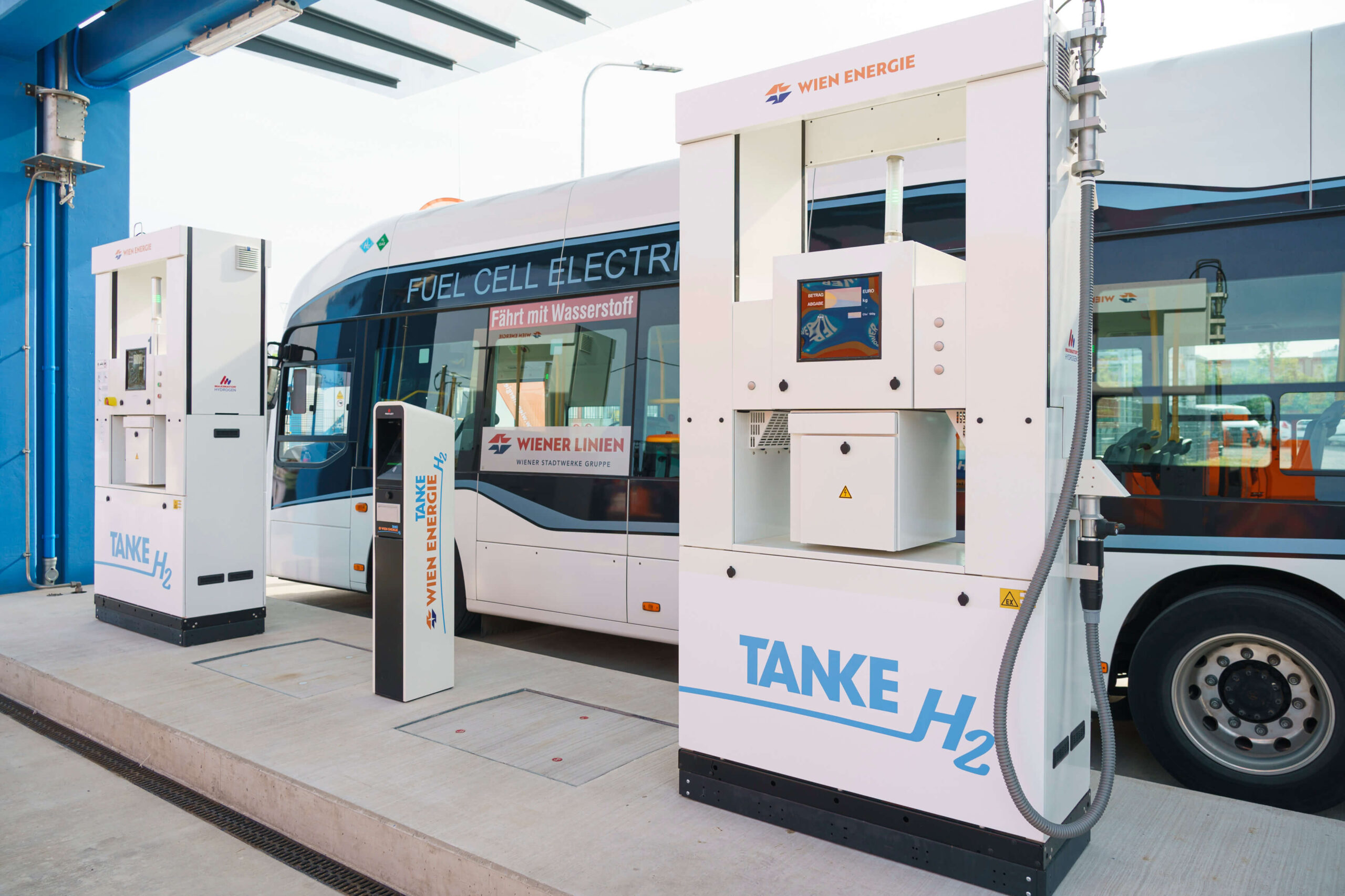 Ein Bus tankt an einer Tankstelle, die mit einer modernen Wasserstoff-Erzeugungsanlage ausgestattet ist, was die Umstellung auf saubere Wasserstoff-Energie verdeutlicht.