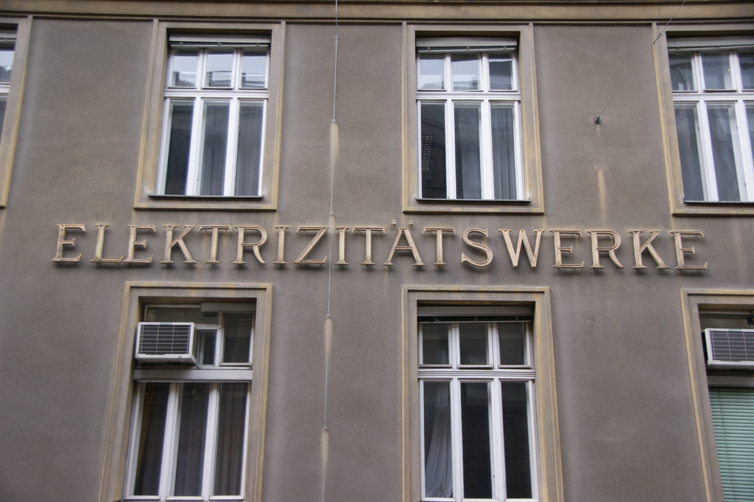 Fassade eines Gebäudes mit großen Fenstern und der Aufschrift „ELEKTRIZITÄTSWERKE“.