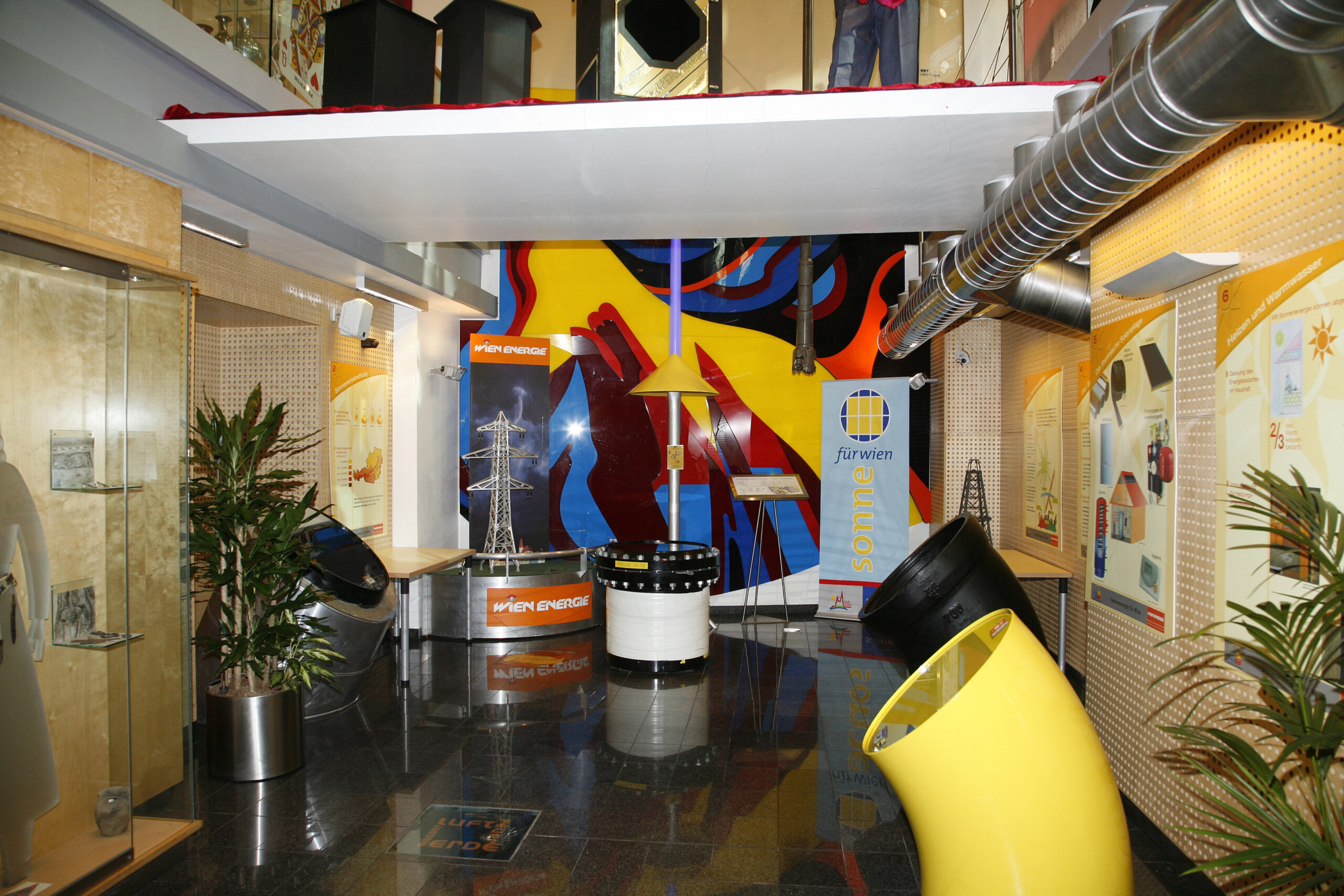 Innenansicht einer farbenfrohen Energieausstellung mit Displays, Pflanzen und Informationstafeln an den Wänden im Wien Energie Haus auf der Mariahilferstraße in Wien.